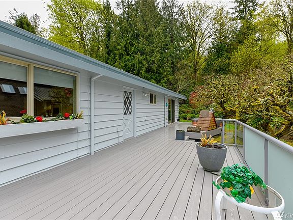 Expansive newer composite deck with glass panel railing, access from the master bedroom at the far end, laundry room in the middle and also slider from the family room off of the kitchen.  This is only a portion of the deck you see in the photo. 