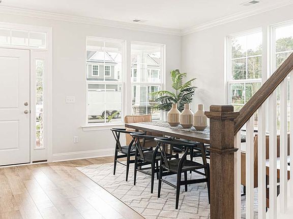Entry and flex room with 2 large adjacent double windows, light wood floors.