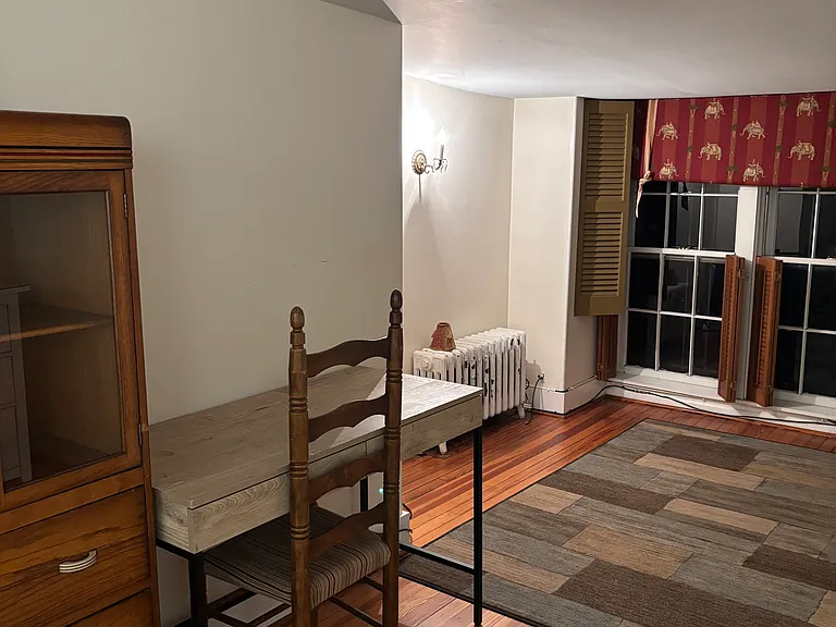 Large three floor bedroom looking from bed to back of room and dresser and desk