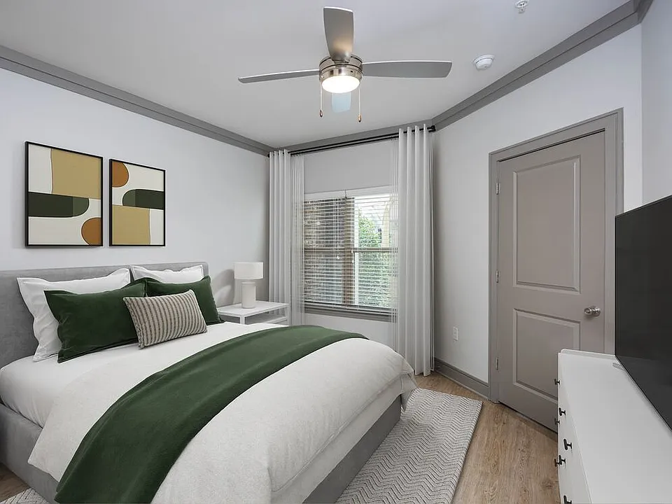Bedroom with hard-surface vinyl plank flooring and ceiling fan