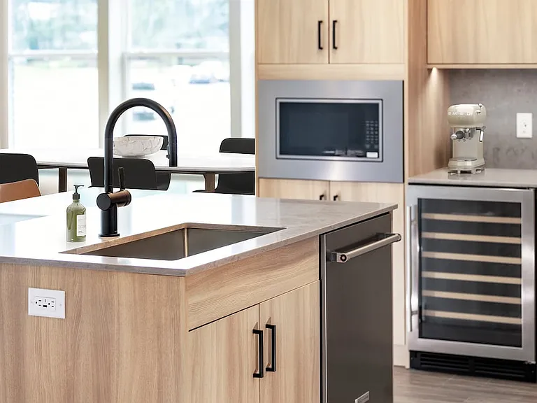 Signature Collection kitchen with stainless steel appliances (wine fridge included), quartz countertops, quartz tile backsplash, oak cabinetry, and hard-surface flooring
