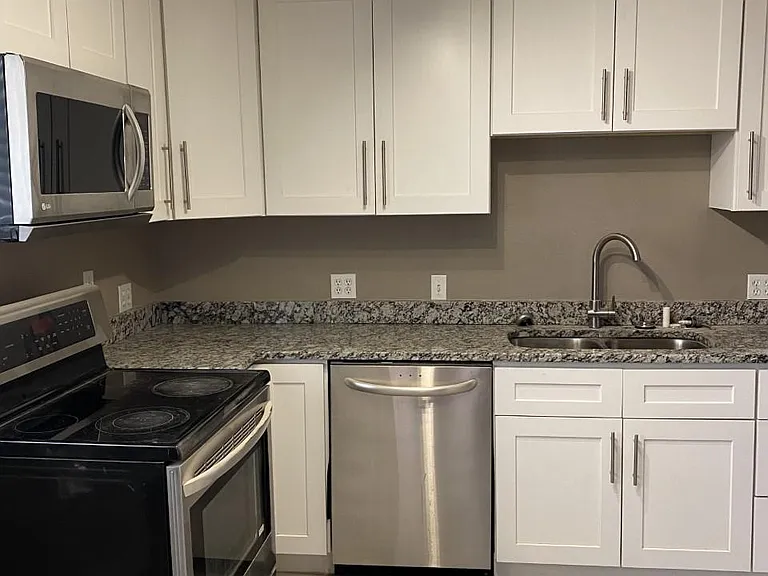 Shaker cabinets, double sink, dishwasher, glass top range, Microwave