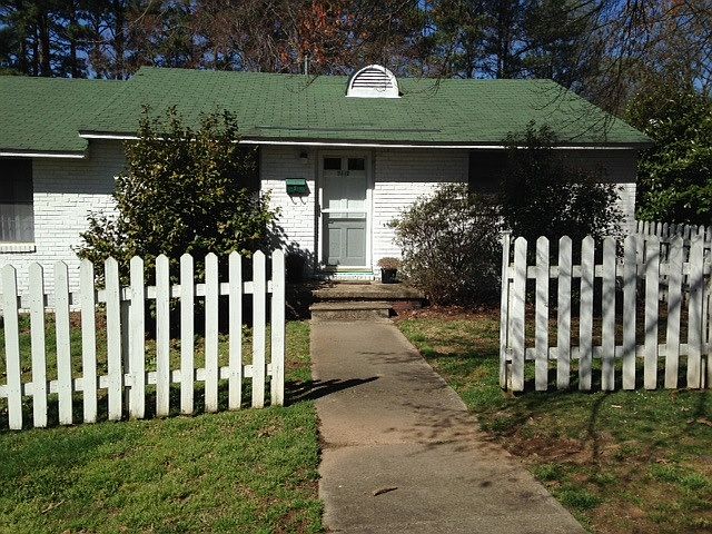 Front door with partially fenced in backyard