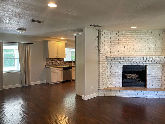 Fireplace in living room with open floor plan into kitchen
