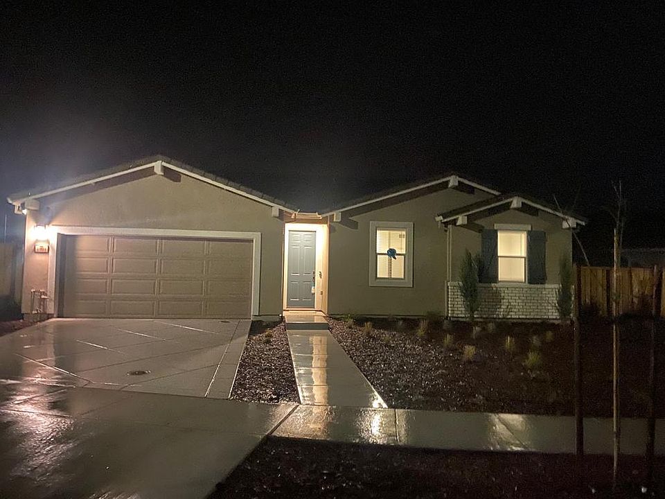 From a distance, the front of the house presents an inviting and well-maintained facade, highlighted by a sleek front door with a modern smart key and Ring doorbell. The carport offers convenient covered parking, while the carefully landscaped surrounding