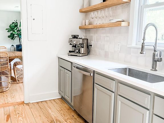 Kitchen with original hardwood floors, new stainless appliances and zellige backsplash
