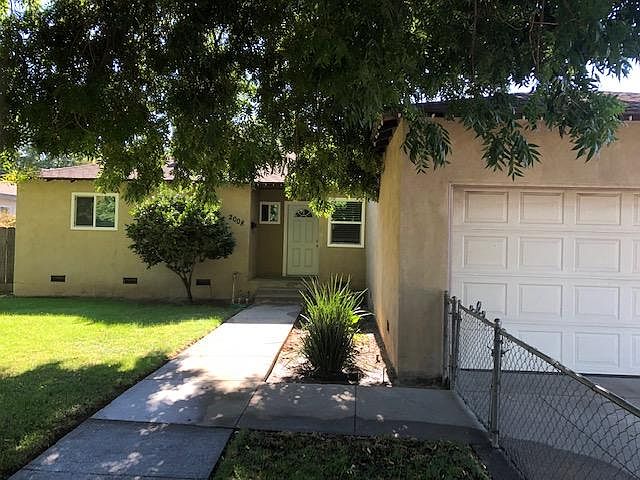 View of the front yard of the house from the sidewalk.