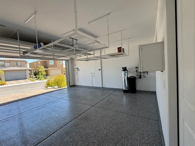 Garage with epoxy floors, EV charger and overhead storage.
