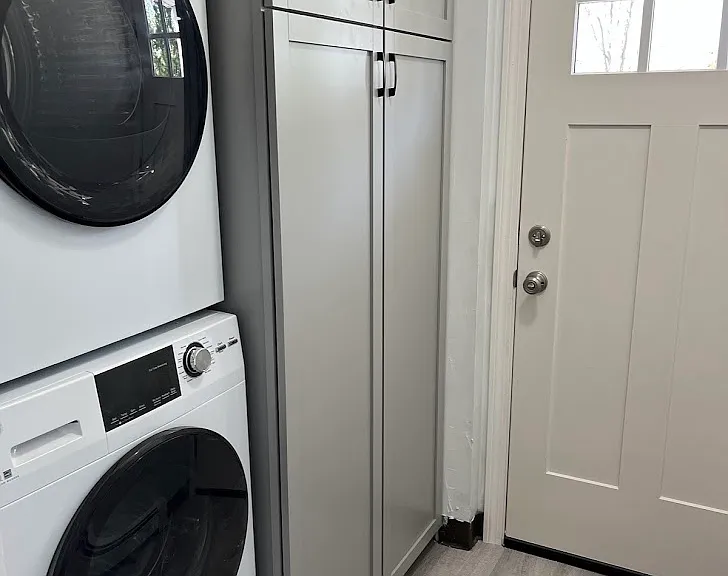 Rear entry to apartment with storage cabinet and laundry.
