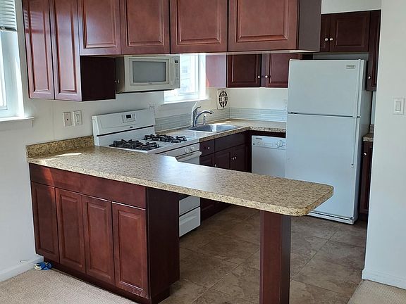 View of kitchen with island and cabinets.