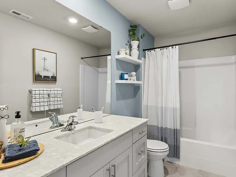 Upper floor bathroom with white cabinet and countertops.