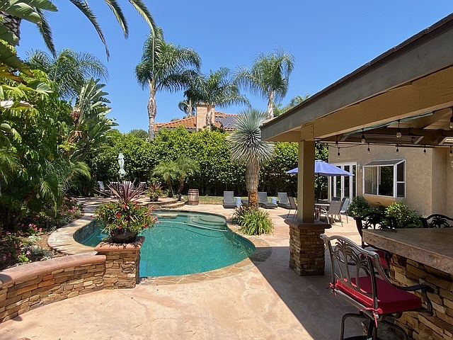 Wonderful backyard with pool/spa, huge bar with fan, two tv's, fridge, kegerator, huge fireplace, and lots of seating available.