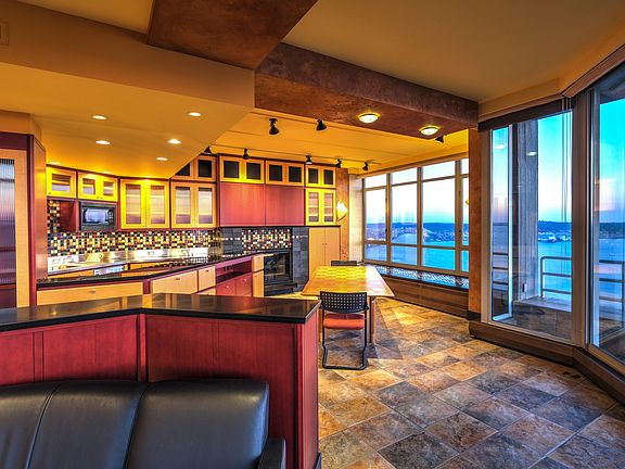 Open concept kitchen features European appliances, plumbed for gas cooking; gas fireplace; granite counters and a stainless counter with a deep sink.