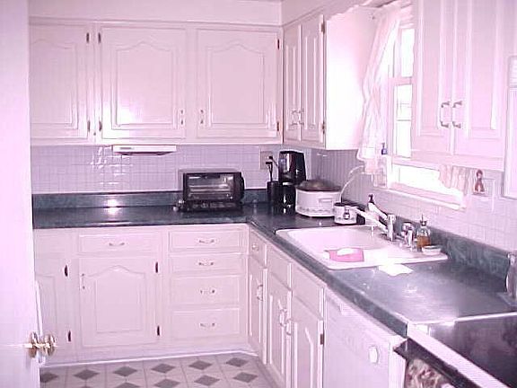 Charming Kitchen with White Cabinets, Appliances and Back Splash