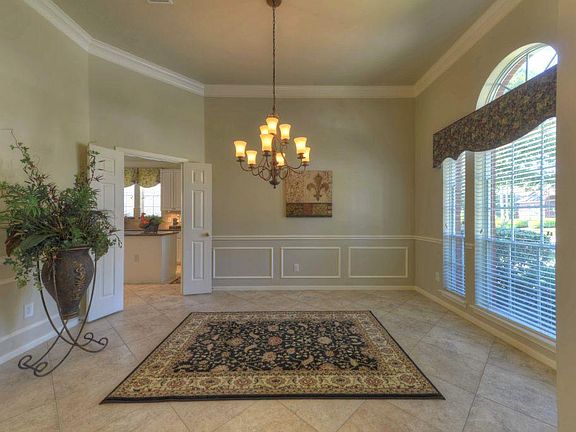 Gorgeous formal dining room boasts extensive millwork, breathtaking chandelier, & beautiful custom w