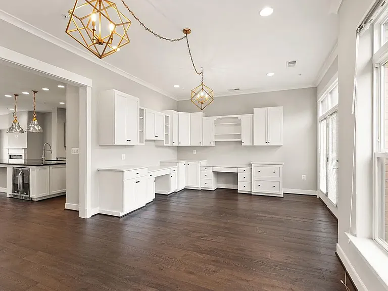 Room adjacent to kitchen (opposite living room/fireplace), with two built in desks and cabinets. Can be used as a dining room, home office, additional entertaining space.