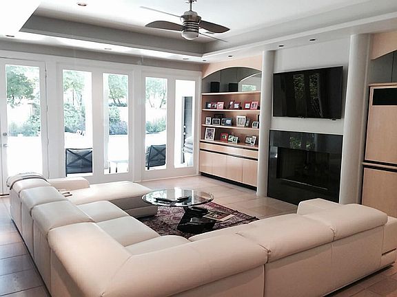 Wall to Wall sunshine and doors overlooking the backyard and the pool in the living room, with built