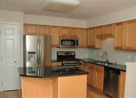 Upgraded kitchen with all stainless steel appliances, island, pantry and tiled back splash