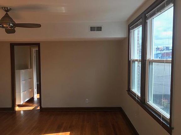 Living Room-with view into hallway, shoe storage bins and bedroom door.