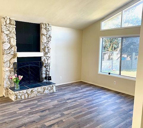 Fireplace in living room with vaulted ceilings.