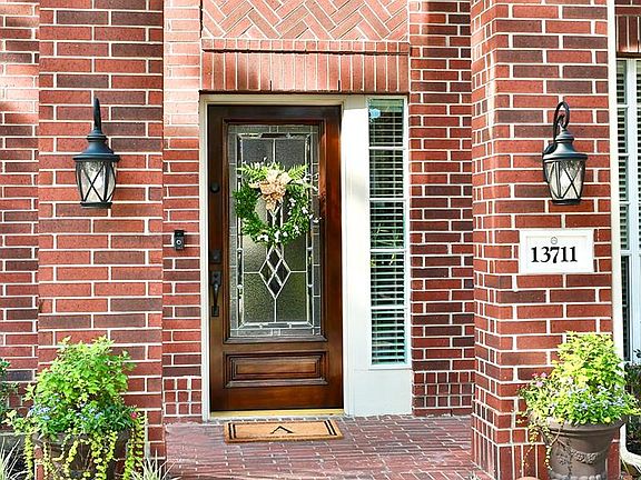 Columns and elegant lighting present and inviting entry.