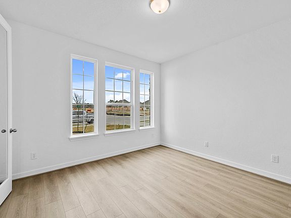 Private study with French doors, beautiful flooring, and large windows-perfect for work, creativity,