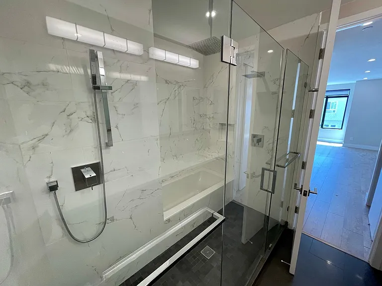 Shower / tub area with 3 shower heads and soaking tub
