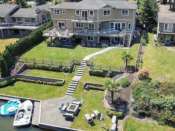 Stunning 4,924 sq ft Lake Tapps Waterfront home. 80 ft of lake frontage. Impeccable landscape, bulkhead, dock, swim area.