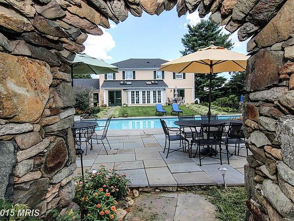 Pool and house view through stone arch