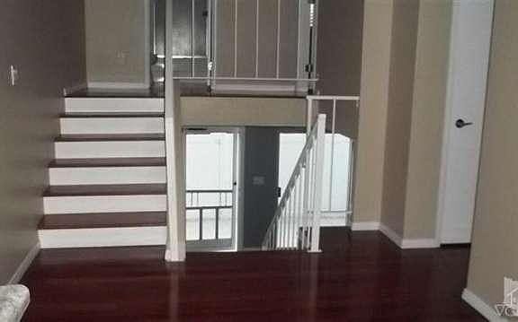 View from dining area, on 2nd area of living space, looking down into living room at pedestrian & sl