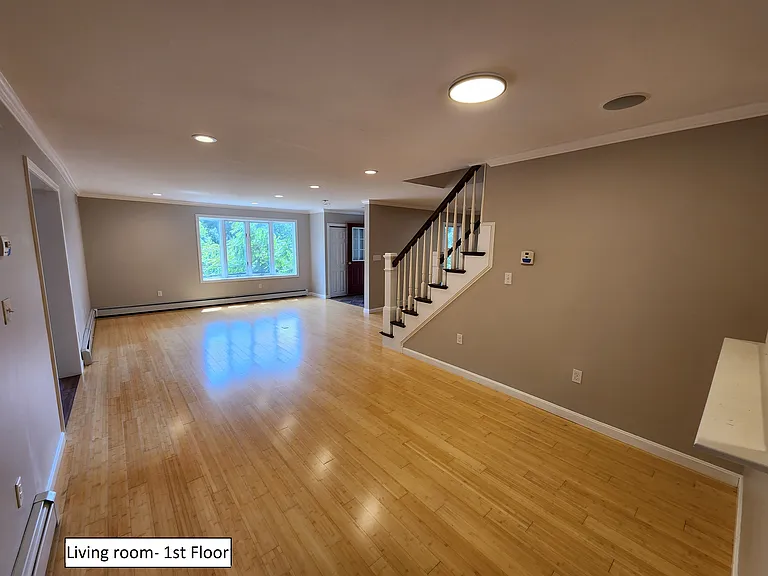 Living room looking towards front of house. Bay window is south facing, lots of natural light