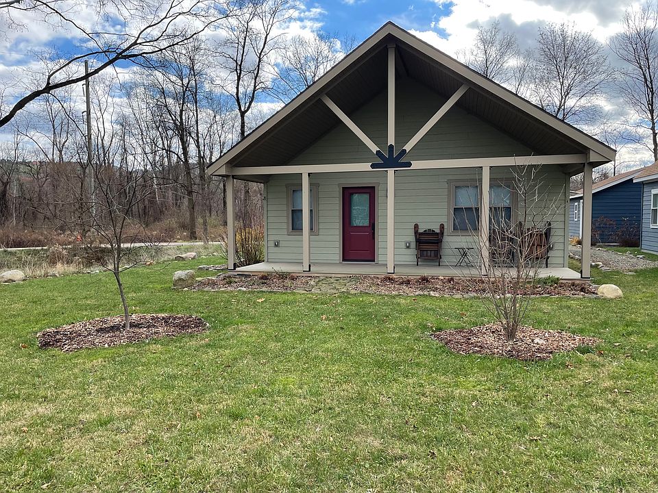 Front porch faces an open lawn area that is over an acre in size and includes a community garden.