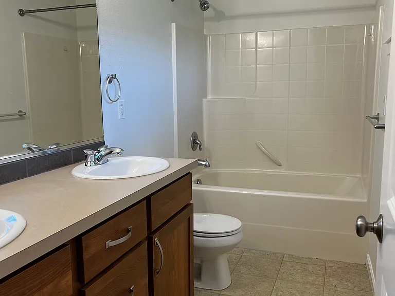 Primary bathroom with new paint, dual vanity, new light fixtures and a window for natural light