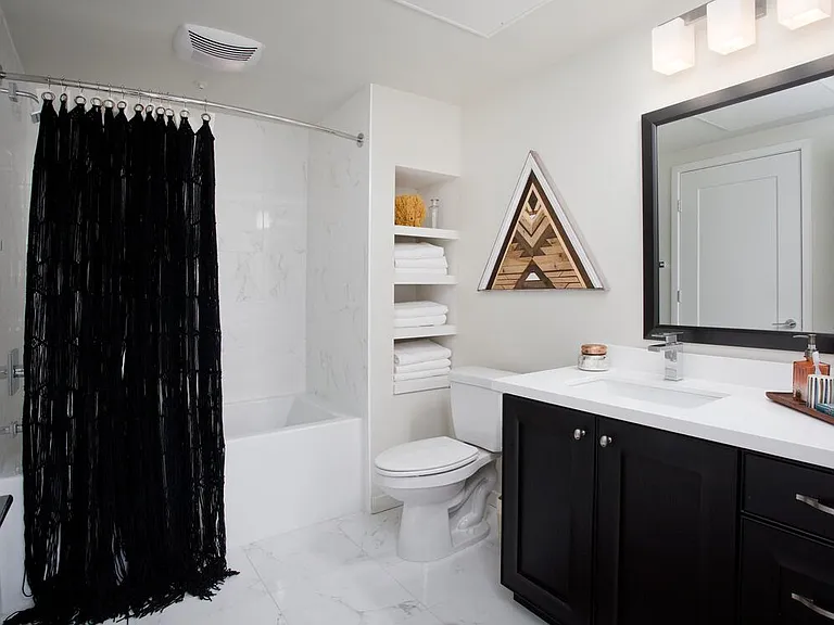 Baths with dark cabinetry, white quartz countertops, and hard surface flooring