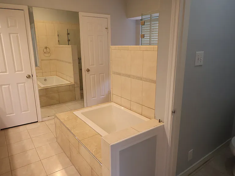 Master bath has full amenities: Toilet room, soaking tub, his/her walk-in closets, shower and small window.