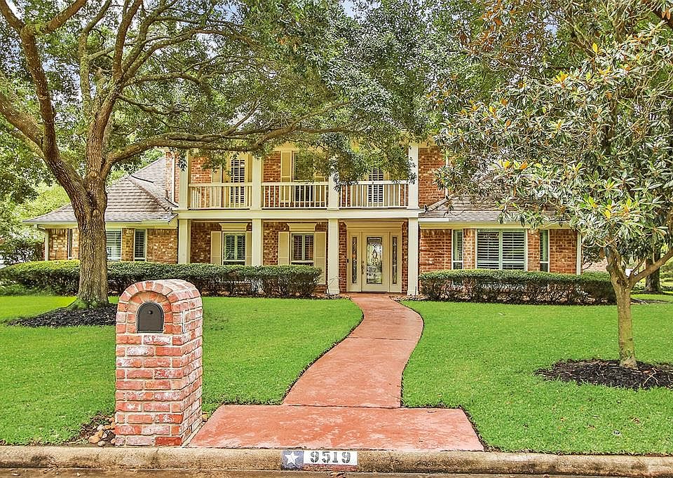 STRIKING CURB APPEAL: Mature trees frame this Champion Forest beauty set on a corner lot. The covered front porch with balcony above create architectural interest that makes this home a stand out.
