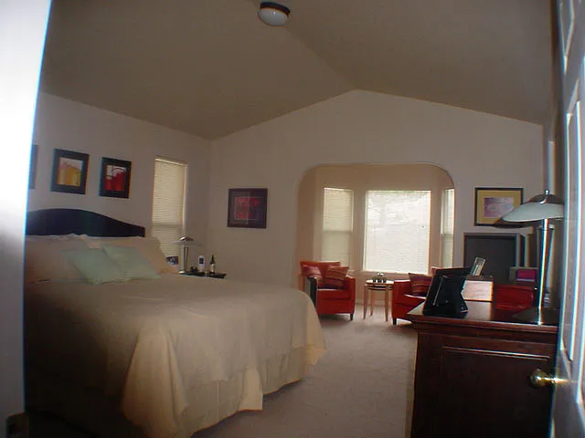 Master Bedroom, adjoining bathroom. Sitting area with windows facing open space.