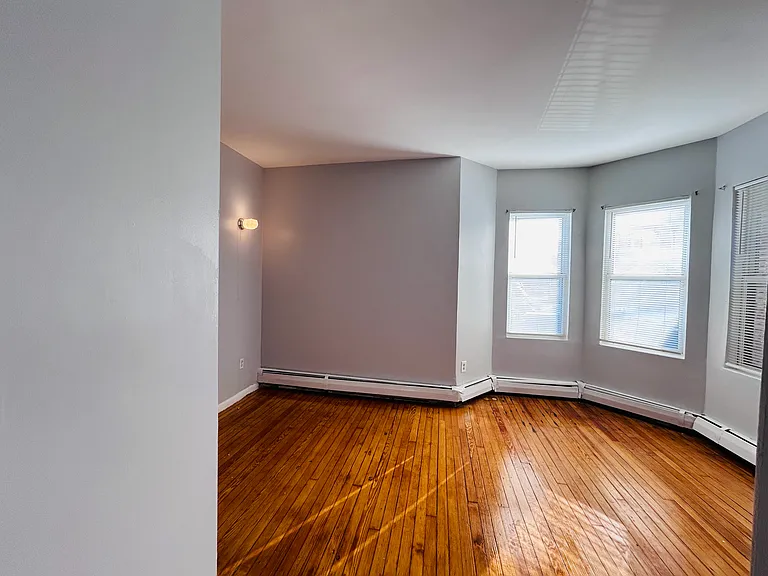 Bedroom 1 (front) with 3 windows and wall sconce light and wall mountable TV outlet