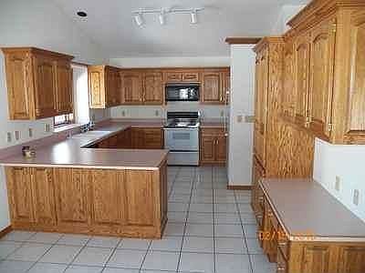 Spacious kitchen with snack bar counter, raised oak panel cabinets, pantry and planning desk
