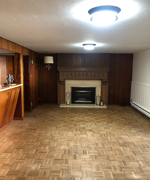 gas fireplace located in the living room, with wet bar to the left