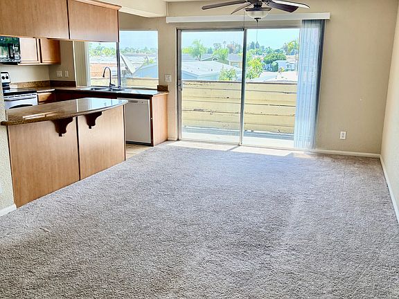 spacious living/dining room with balcony off of kitchen