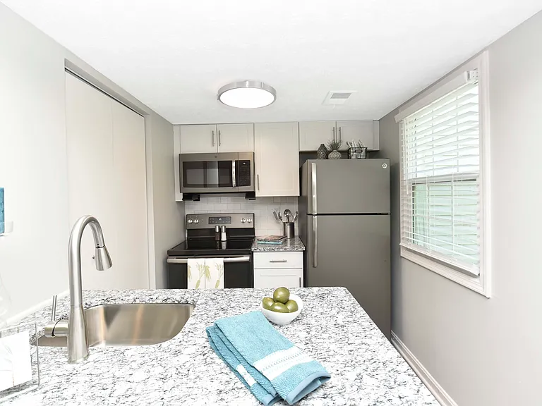 Kitchen with granite counters, modern cabinetry, and stainless appliances