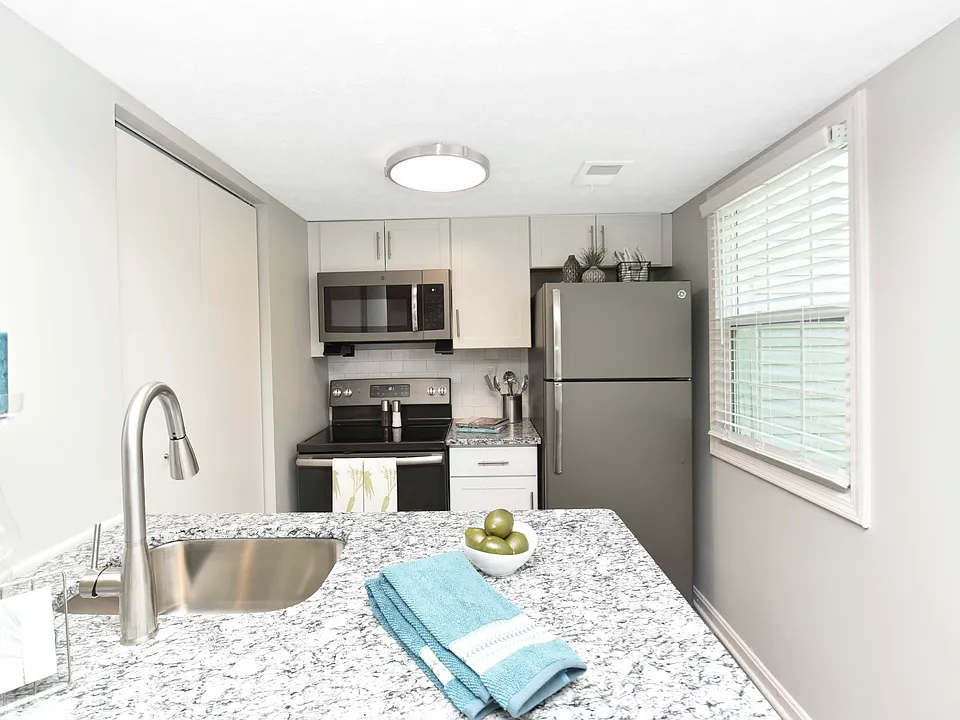 Kitchen with granite counters, modern cabinetry, and stainless appliances