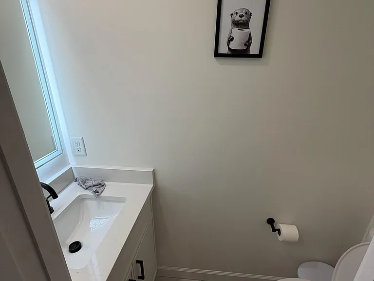 Half bath with a single-sink vanity, under-cabinet storage, and a window that brings in natural light.