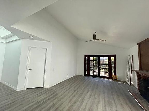 Living room with vaulted ceilings - fireplace and new floors
