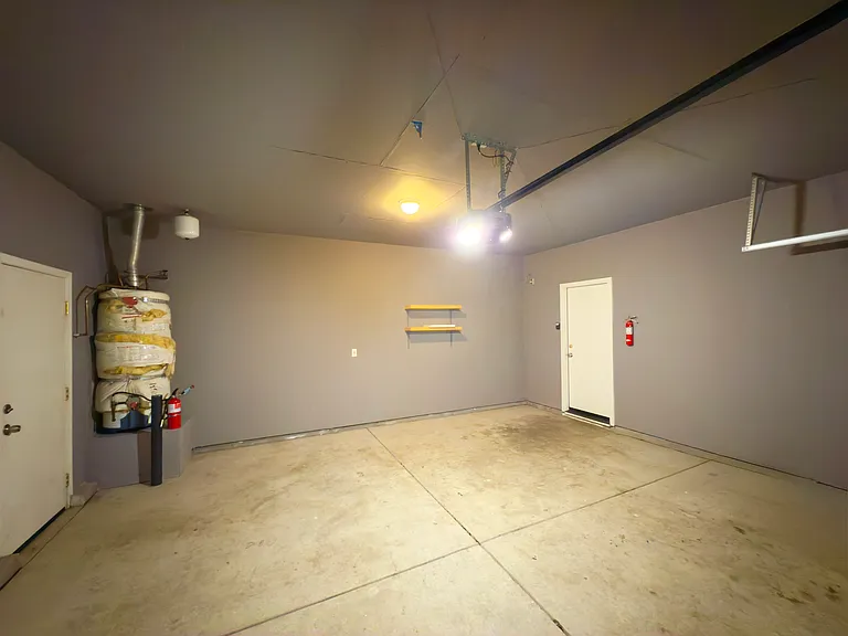 Spacious garage with a fresh coat of paint and a brand-new door featuring windows for added natural light and style!