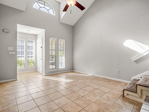 COME ON IN!! The moment you walk in you are greeted with HIGH CEILINGS and lots of windows bringing in some great light into the living room of the home! The door that is seen in this picture is the front door entrance to the home.