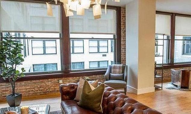 Living room surrounded by large oversized windows which gives an open feel and lets natural light in.