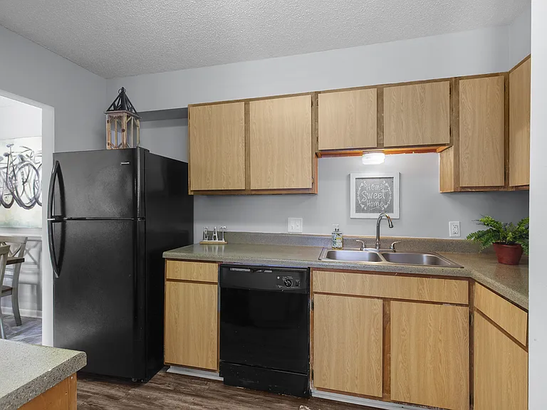 Sleek, matching black appliances and warm wooden cabinetry come together in the kitchens at Lakeland East Apartments in Flowood, MS. Managed by Highlands Vista Group.