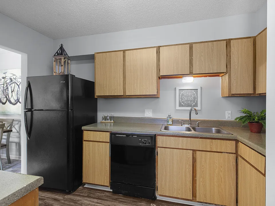 Sleek, matching black appliances and warm wooden cabinetry come together in the kitchens at Lakeland East Apartments in Flowood, MS. Managed by Highlands Vista Group.